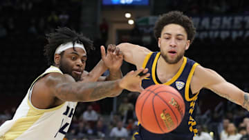 Akron guard Seth Wilson (left) and Toledo guard Sam Lewis pursue a first-half loose ball during the Mid-American Conference Tournament semifinals at Rocket Arena.