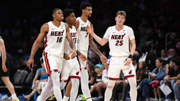 Oct 8, 2025; Miami, Florida, USA;  Miami Heat guard Kasparas Jakucionis (25) is congratulated by forward Keshad Johnson (16), forward Myron Gardner (15) and center Kel'El Ware (7) during a timeout in the second half against the San Antonio Spurs at Kaseya Center. Mandatory Credit: Jim Rassol-Imagn Images