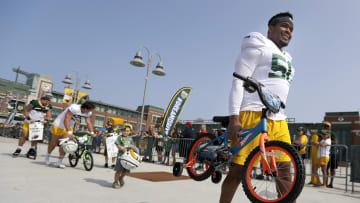 Green Bay Packers offensive lineman Zach Tom takes a bike to practice at training camp last year.
