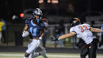 Guilford running back Messiah Tilson runs past Freeport's Riley Rushing during the first half of their game at Guilford High School in Rockford.
