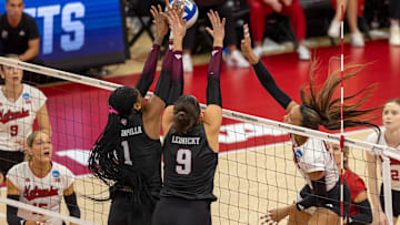 Texas A&M middle blocker Ifenna Cos-Okpalla and opposite hitter  Logan Lednicky block an attack from Nebraska outside hitter Harper Murray.