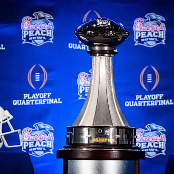The Peach Bowl trophy is displayed next to the Texas Longhorns and Arizona State Sun Devils helmets during the Joint Head Coaches Press Conference at the Westin Peachtree Plaza in Atlanta, Georgia on Dec. 31, 2024, ahead of the Peach Bowl College Football Quarterfinal Game on New Years Day. Texas Longhorns Head Coach Steve Sarkisian joined Arizona Sun Devils Head Coach Kenny Dillingham at the press conference.