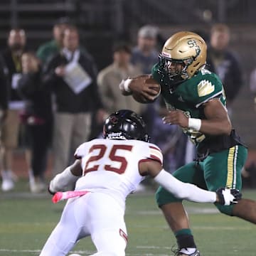 St. Bonaventure's Delon Thompson looks for an opening as Oaks Christian's Davon Benjamin tries for the tackle during the first quarter of their Marmonte League game at Ventura College on Thursday, Oct. 27, 2022. St. Bonaventure won 40-28 to earn the league championship.