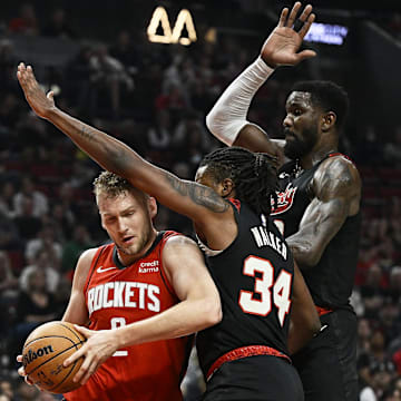 Apr 12, 2024; Portland, Oregon, USA; Houston Rockets center Jock Landale (2) drives to the basket during the first half against Portland Trail Blazers forward Jabari Walker (34) and center Deandre Ayton (2) at Moda Center. Mandatory Credit: Troy Wayrynen-Imagn Images