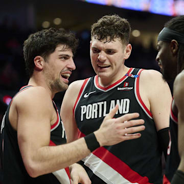 Feb 22, 2025; Portland, Oregon, USA; Portland Trail Blazers center Donovan Clingan (23) and forward Jerami Grant (9) celebrate with forward Deni Avdija (8) during the second half against the Charlotte Hornets at Moda Center. Mandatory Credit: Troy Wayrynen-Imagn Images