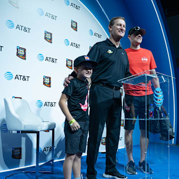 Beckett Bingham, 9, and father Clark Bingham take a photo with Oregon Ducks coach Dana Altman at the NCAA Men’s Final Four Fan Fest at the Phoenix Convention Center on April 7, 2024, in Phoenix.