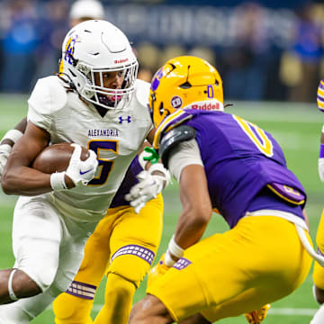 An Edna Karr defender (purple) prepares to tackle Alexandria RB JT Lindsey in the 2024 championship game won handily by the Cougars.