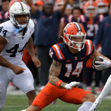 Sep 16, 2023; Champaign, Illinois, USA;  Illinois Fighting Illini wide receiver Casey Washington (14) runs the ball against Penn State Nittany Lions safety Keaton Ellis (2) during the first half at Memorial Stadium. Mandatory Credit: Ron Johnson-USA TODAY Sports