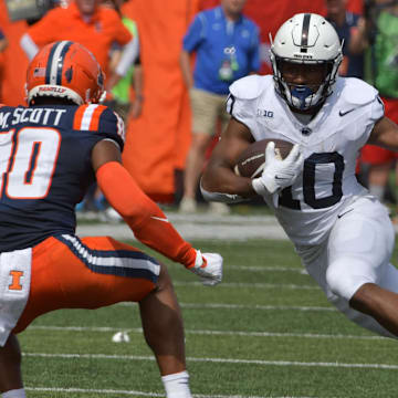 Sep 16, 2023; Champaign, Illinois, USA;  Penn State Nittany Lions running back Mehdi Flowers (right) runs the ball against Illinois Fighting Illini defensive back Miles Scott (10) during the first half at Memorial Stadium. Mandatory Credit: Ron Johnson-Imagn Images