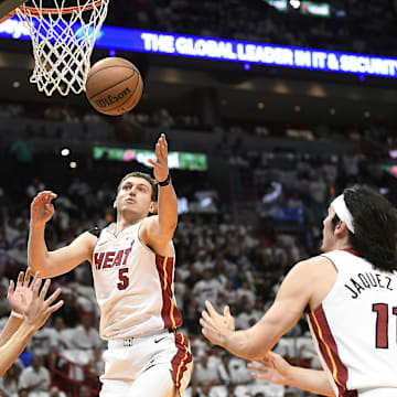 Apr 29, 2024; Miami, Florida, USA; Miami Heat forward Nikola Jovic (5) reaches for the ball in front of Boston Celtics guard Derrick White (9) during the first quarter of game four of the first round for the 2024 NBA playoffs at Kaseya Center. Mandatory Credit: Michael Laughlin-Imagn Images