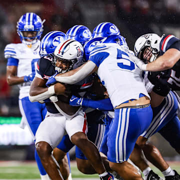 Oct 11, 2025; Tucson, Arizona, USA; Brigham Young Cougars attempts to tackle Arizona Wildcats running back Kedrick Reescano (3) during the second quarter of the game at Arizona Stadium. Mandatory Credit: Aryanna Frank-Imagn Images