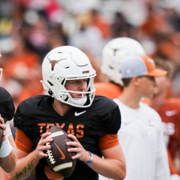 Texas Longhorns quarterbacks Arch Manning (16), left, and Quinn Ewers (3) throw passes while warming up ahead of the Longhorns' spring Orange and White game at Darrell K Royal-Texas Memorial Stadium in Austin, Texas, April 20, 2024.