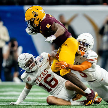 Texas Longhorns defensive backs Malik Muhammad (5) and Michael Taaffe (16) work together to bring down Arizona State Sun Devils wide receiver Melquan Stovall (5) in the fourth quarter as the Texas Longhorns play the Arizona State Sun Devils in the Peach Bowl College Football Playoff quarterfinal at Mercedes-Benz Stadium in Atlanta, Georgia, Jan. 1, 2025.