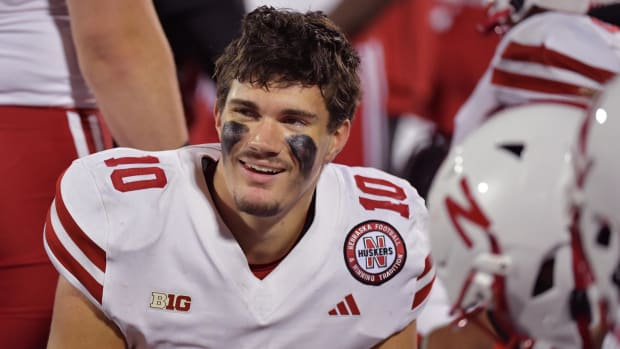 Nebraska Cornhuskers quarterback Heinrich Haarberg (10) smiles with teammates on the bench 