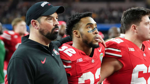 Head coach and running back stand next to each other during Carmen Ohio singing.