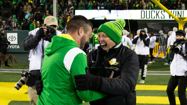 Oregon coach Dan Lanning, left, and Oregon Athletic Director Rob Mullen celebrate the win over Utah after the game at Autzen