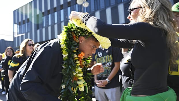 Oregon Ducks quarterback Dillon Gabriel (8) receives flowers leis from family before a game against the Ohio State Buckeyes