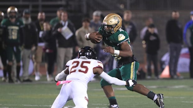 St. Bonaventure's Delon Thompson looks for an opening as Oaks Christian's Davon Benjamin tries for the tackle