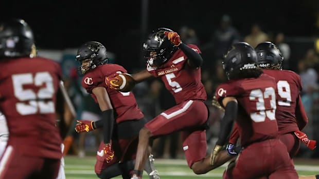 Oaks Christian's Davon Benjamin leaps through an opening after making an interception of a St. Bonaventure pass
