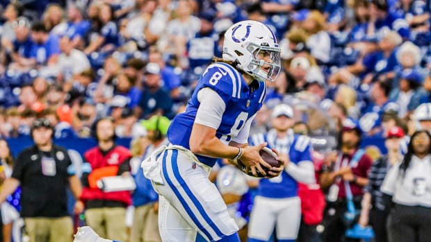 Colts quarterback Jason Bean (blue jersey with white helmet) runs with the football to gain yards. 