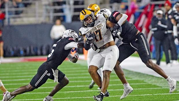 Kennesaw State's Gerard Bullock Jr. tries to evade the tackle of Jacksonville State's Tyrin Taylor and Isaac Walker.