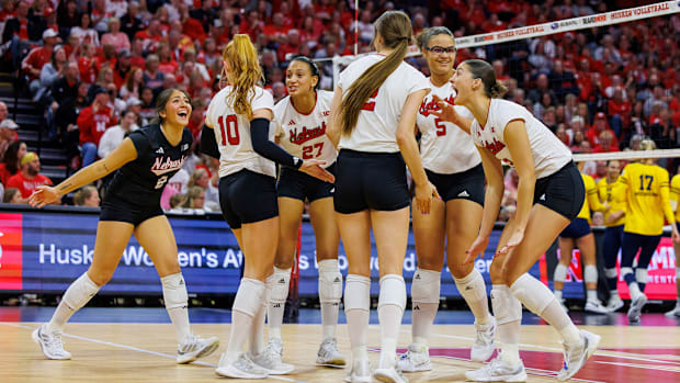 Nebraska volleyball players celebrate a point against Michigan.