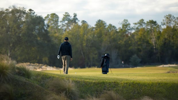 A golfer models Sun Day Red apparel.