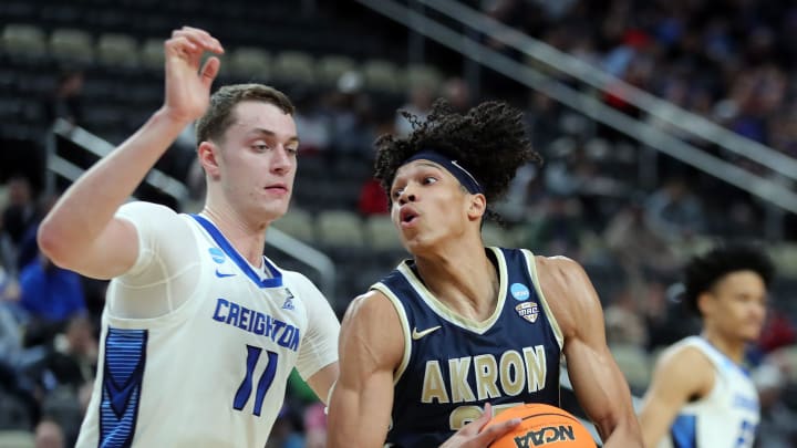 Akron's Enrique Freeman (25) drives against Creighton's Ryan Kalkbrenner (11) during the first half of an NCAA Tournament first-round game Thursday in Pittsburgh.