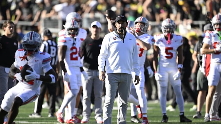 Oct 12, 2024; Eugene, Oregon, USA; Ohio State Buckeyes head coach Ryan Day watches players warm up before a game against the Oregon Ducks at Autzen Stadium. Mandatory Credit: Troy Wayrynen-Imagn Images