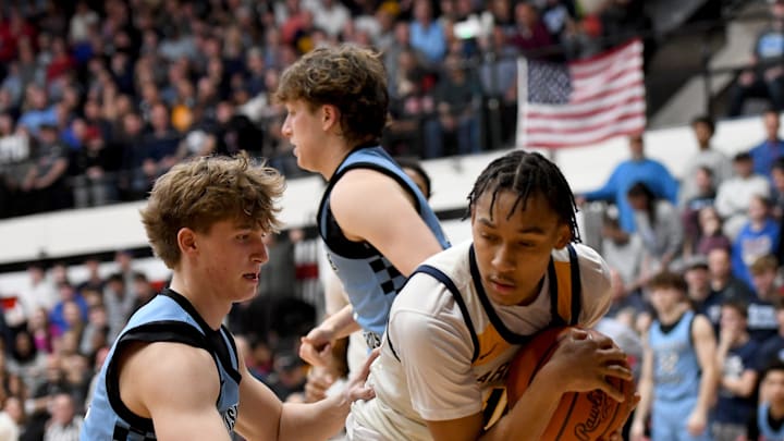 Garfield Heights' Marcus Johnson (right) covers up a rebound as Louisville's Ashton Marshall defends during an OHSAA Division III boys basketball state semifinal at Canton Memorial Field House on Sunday, March 16, 2025.