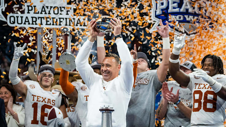 Texas Longhorns head coach Steve Sarkisian raises the trophy as the Texas Longhorns celebrate their 39-31 double overtime win over the Arizona State Sun Devils in the Peach Bowl College Football Playoff quarterfinal at Mercedes-Benz Stadium in Atlanta, Georgia, Jan. 1, 2025.
