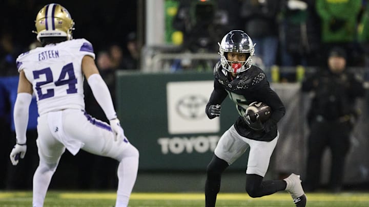 Nov 30, 2024; Eugene, Oregon, USA; Oregon Ducks wide receiver Tez Johnson (15) catches a pass during the second half against Washington Huskies safety Makell Esteen (24) at Autzen Stadium. Mandatory Credit: Troy Wayrynen-Imagn Images