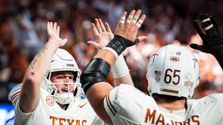 Texas Longhorns quarterback Quinn Ewers (3) celebrates with Texas Longhorns offensive lineman Jake Majors (65) after scoring a touchdown in the fourth quarter as the Texas Longhorns play the Arizona State Sun Devils in the Peach Bowl College Football Playoff quarterfinal at Mercedes-Benz Stadium in Atlanta, Georgia, Jan. 1, 2025.