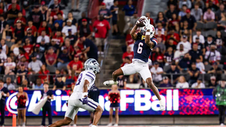 Sep 12, 2025; Tucson, Arizona, USA; Arizona Wildcats wide receiver Javin Whatley (6) catches the ball while Kansas State Wildcats defensive end Chiddi Obiazor (8) defends during the second quarter of the game at Arizona Stadium. Mandatory Credit: Aryanna Frank-Imagn Images