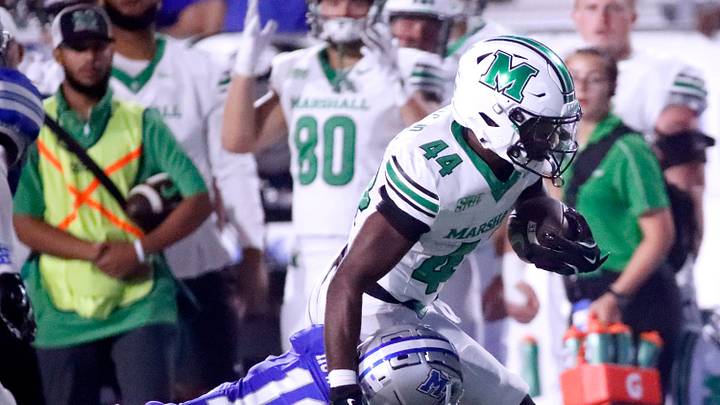 Marshall running back Antwan Roberts (44) carries the ball as Middle Tennessee safety Juwon Gaston (22) dives for a tackle during MTSU's Homecoming football game on Saturday, Sept. 20, 2025.