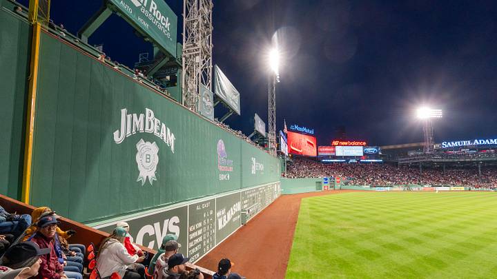 Fans watch the Boston Red Sox take on the New York Yankees at the base of the Green Monster April 23 at Fenway Park in Boston.