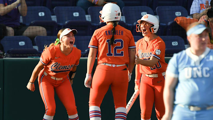 Clemson Jamison Brockenbrough (9), left, and Sam Minish (20), right, greet teammate Julia Knowler (12) scoring against University of North Carolina during the bottom of the first inning at McWhorter Stadium in Clemson Friday, March 14, 2025.