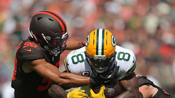 Green Bay Packers running back Josh Jacobs (8) is brought down by Cleveland Browns defensive end Joe Tryon-Shoyinka (90) and linebacker Carson Schwesinger (49) during the first half of an NFL football game at Huntington Bank Field, Sept. 21, 2025, in Cleveland, Ohio.