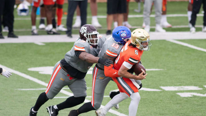 Former Texas A&M DL McKinnley Jackson (3) and Houston Christian LB Jalyx Hunt (13) converge to take down Notre Dame QB Sam Hartman (5) during the Reese's Senior Bowl in Mobile, Alabama on Saturday, Feb. 3, 2024.