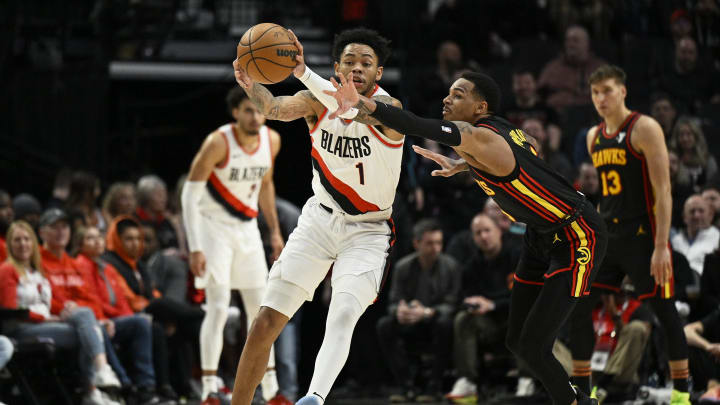 Mar 13, 2024; Portland, Oregon, USA; Atlanta Hawks guard Dejounte Murray (5) attempts to steal the basketball during the first half against Portland Trail Blazers guard Anfernee Simons (1) at Moda Center. Mandatory Credit: Troy Wayrynen-USA TODAY Sports