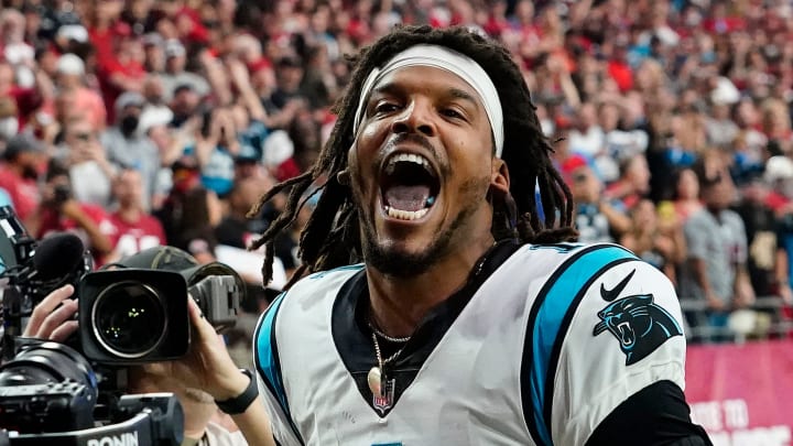 Carolina Panthers quarterback Cam Newton yells \"I'm back!\" after scoring a rushing touchdown against the Arizona Cardinals in a game in 2021.