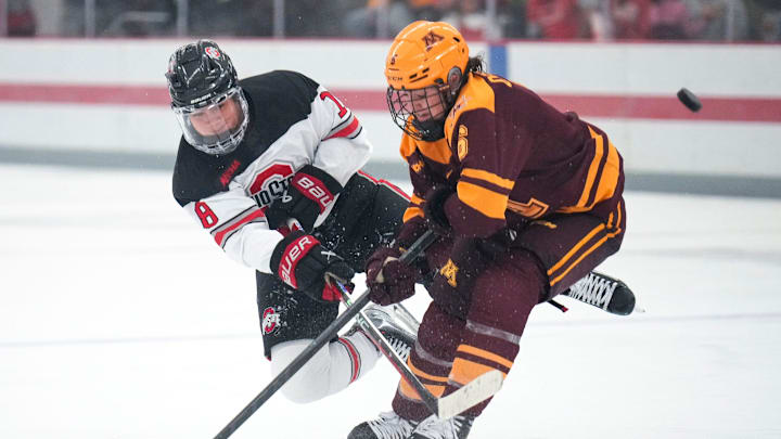 Oct 29, 2022; Columbus, Ohio, USA;  Ohio State University defense Sophie Jaques (18) hits the puck past University of Minnesota defense Madeline Wethington (5) during the third period at Ohio State Ice Rink. Mandatory Credit: Joseph Scheller-The Columbus Dispatch

Hockey Osu Women Hockey