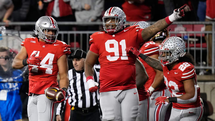 Nov 18, 2023; Columbus, Ohio, USA; Ohio State Buckeyes linebacker Steele Chambers (22) and defensive tackle Tyleik Williams (91) celebrate an interception by defensive end JT Tuimoloau (44) during the NCAA football game against the Minnesota Golden Gophers at Ohio Stadium.