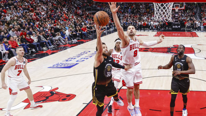 Golden State Warriors guard Stephen Curry (30) goes to the basket against Chicago Bulls center Nikola Vucevic (9) during the second half of an NBA game at United Center.