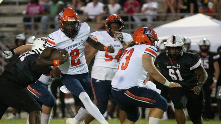 Escambia quarterback Nino Freeman (No. 2) slips out of the backfield for positive yardage during Friday night's season opener against West Florida.