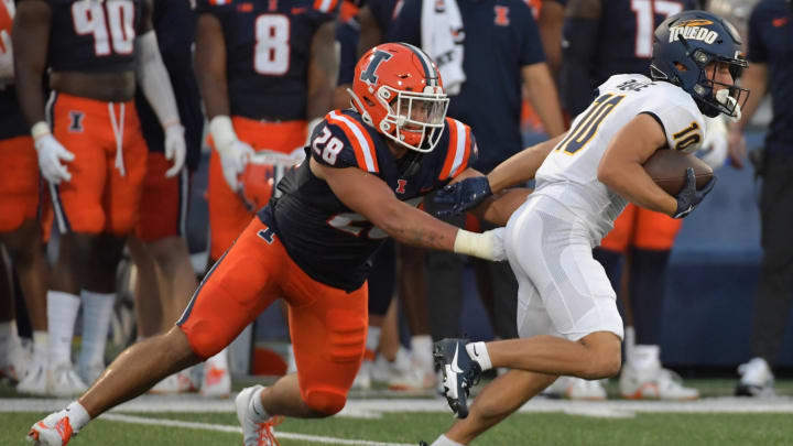 Sep 2, 2023; Champaign, Illinois, USA;  Toledo Rockets wide receiver Jermaine Foster (10) tries to elude the tackle of \Illinois Fighting Illini linebacker Dylan Rosiek (28)during the first half at Memorial Stadium. Mandatory Credit: Ron Johnson-USA TODAY Sports