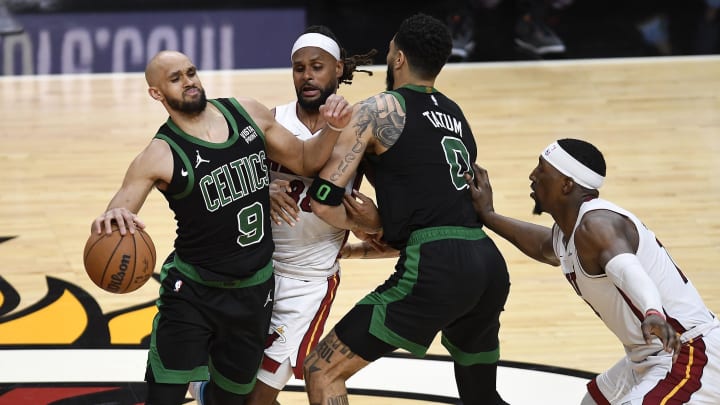 Apr 29, 2024; Miami, Florida, USA; Boston Celtics guard Derrick White (9) tries to dribble around teammate Jayson Tatum (0) as Miami Heat guard Patty Mills (88) defends during the fourth quarter of game four of the first round for the 2024 NBA playoffs at Kaseya Center. Mandatory Credit: Michael Laughlin-USA TODAY Sports