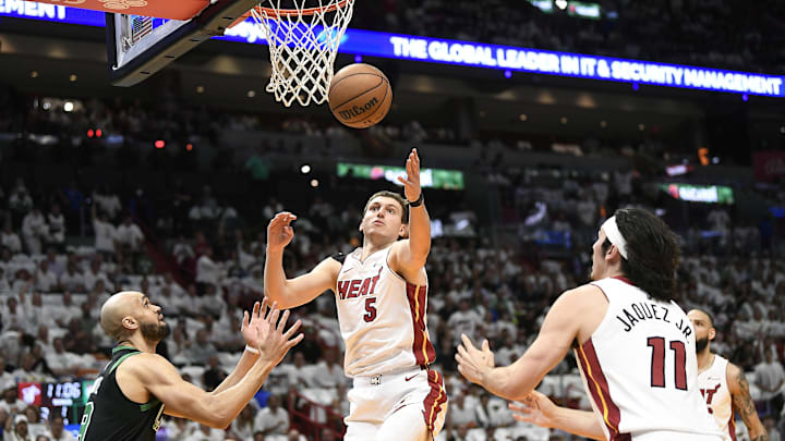 Apr 29, 2024; Miami, Florida, USA; Miami Heat forward Nikola Jovic (5) reaches for the ball in front of Boston Celtics guard Derrick White (9) during the first quarter of game four of the first round for the 2024 NBA playoffs at Kaseya Center. Mandatory Credit: Michael Laughlin-Imagn Images