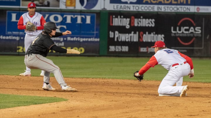 Stockton Ports' Bjay Cooke, right, starts a run down on Modesto Nuts' Colt Emerson in April.