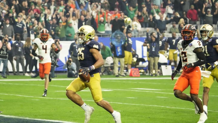 Jan 1, 2022; Glendale, Arizona, USA; Notre Dame Fighting Irish running back Chris Tyree (25) scores a touchdown against the Oklahoma State Cowboys in the first half of the PlayStation Fiesta Bowl at State Farm Stadium.